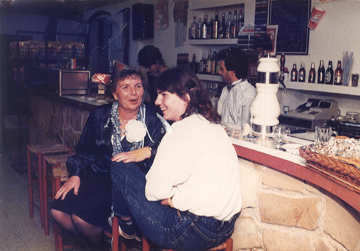 Dos mujeres charlando y riendo en la barra del bar del camping durante una fiesta