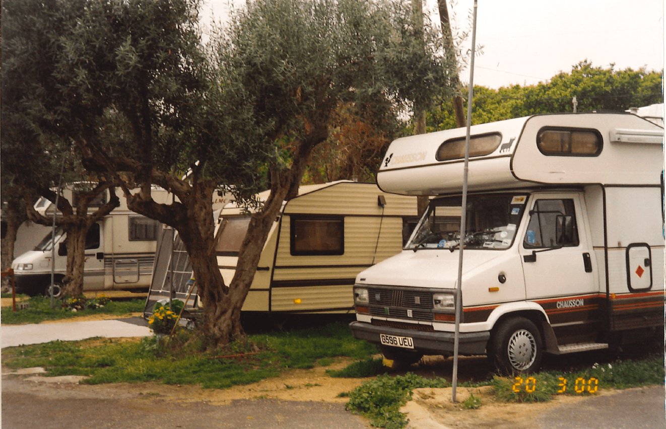 Caravanas y autocaravanas entre olivos en el camping durante el invierno