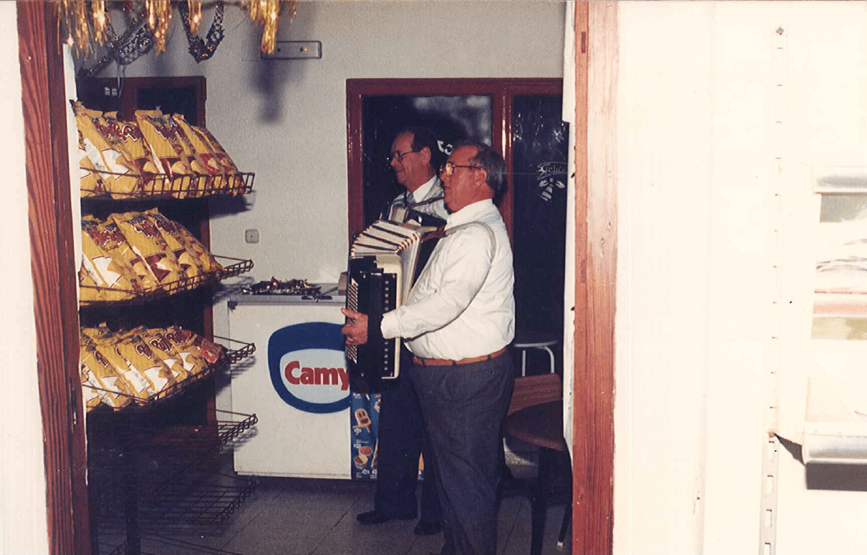 Dos hombres tocando el acordeón junto a la tienda del camping