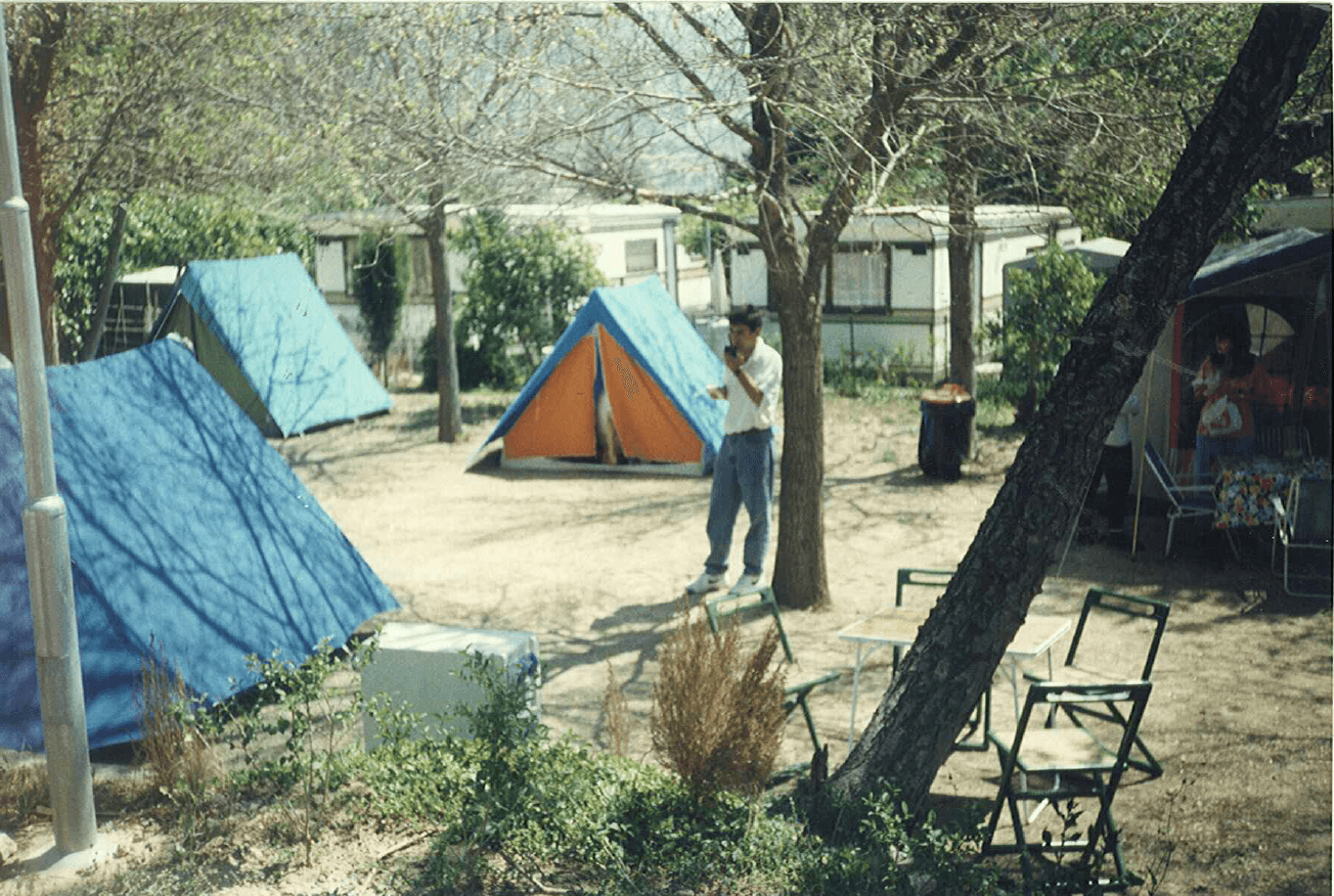 Tiendas de campaña de los años 90 instaladas entre autocaravanas en el camping