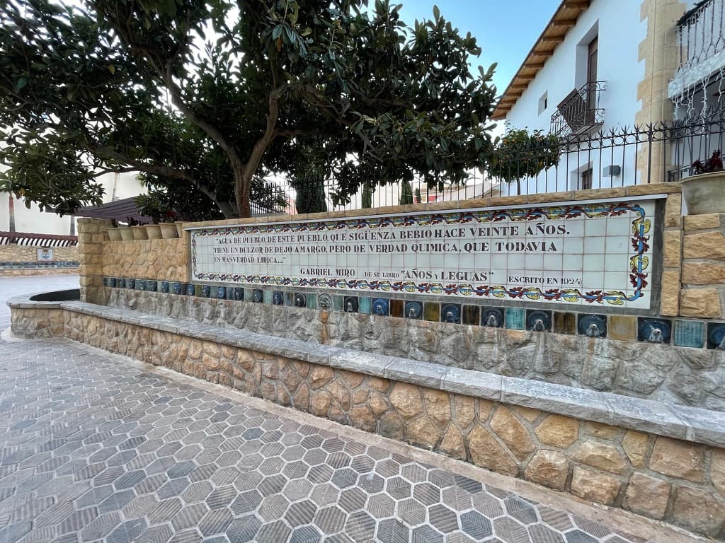 Piastrella del muro con un testo di Gabriel Miró sull’acqua di paese, sopra la fila di getti