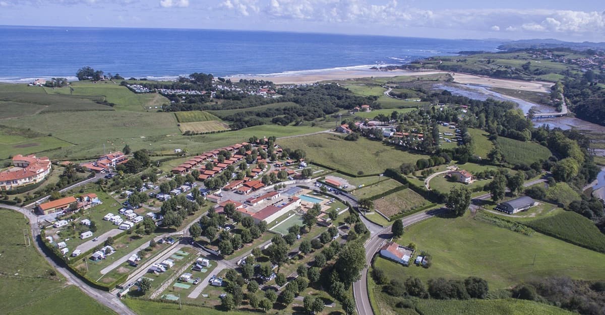 Luchtfoto van Caravaning Oyambre met de Cantabrische kust op de achtergrond
