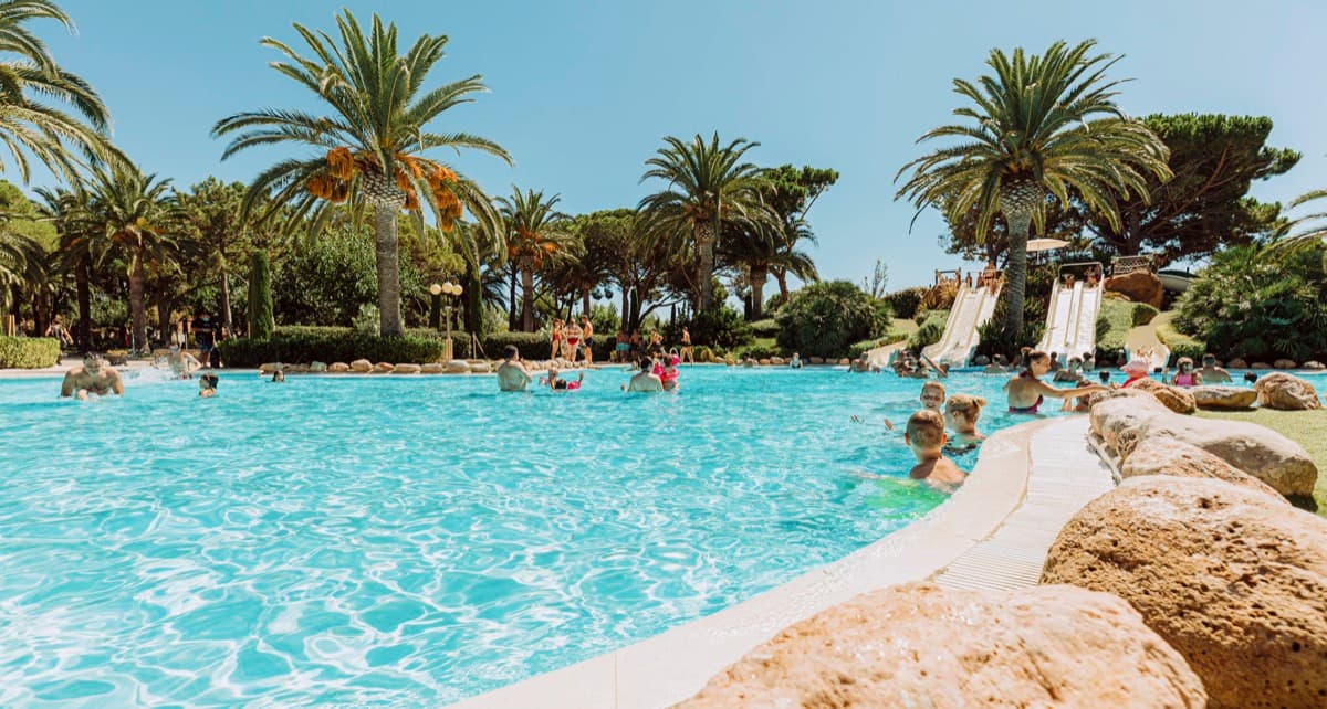 Zwembad omringd door palmbomen bij Playa Montroig Camping Resort