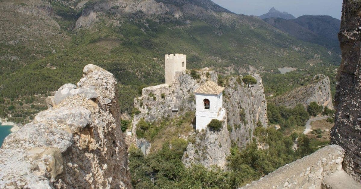 Der Glockenturm und die Überreste der Burg von Guadalest zwischen den Bergen