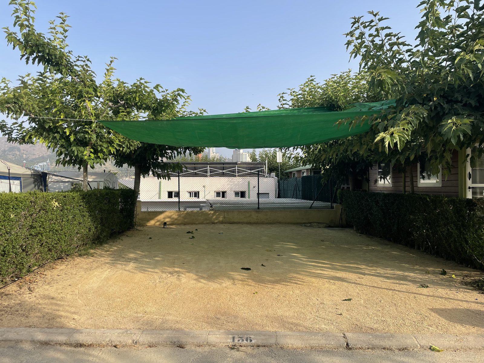 Parcela con toldo verde en Camping Armanello