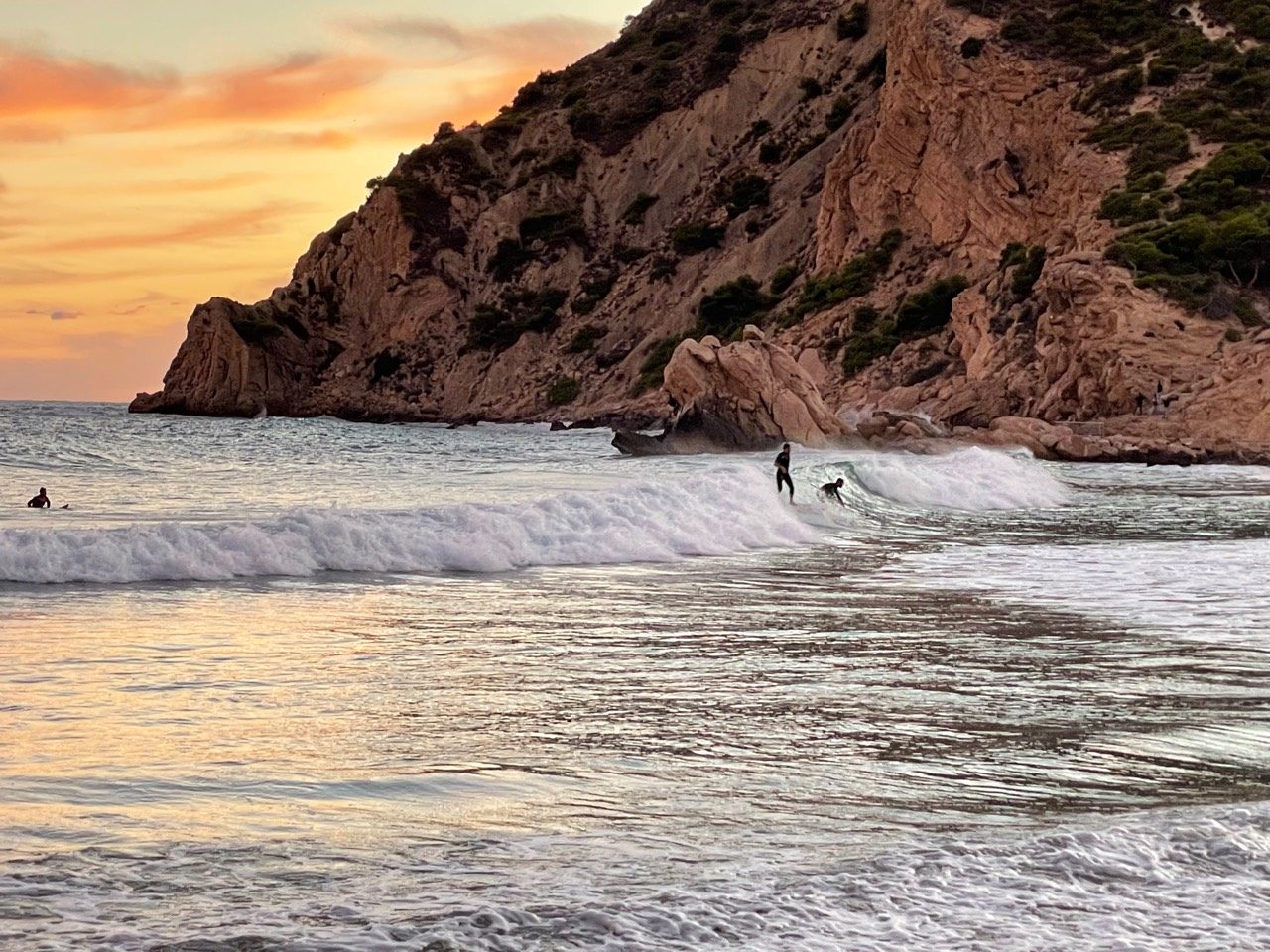 Atardecer con surfista en playa Poniente