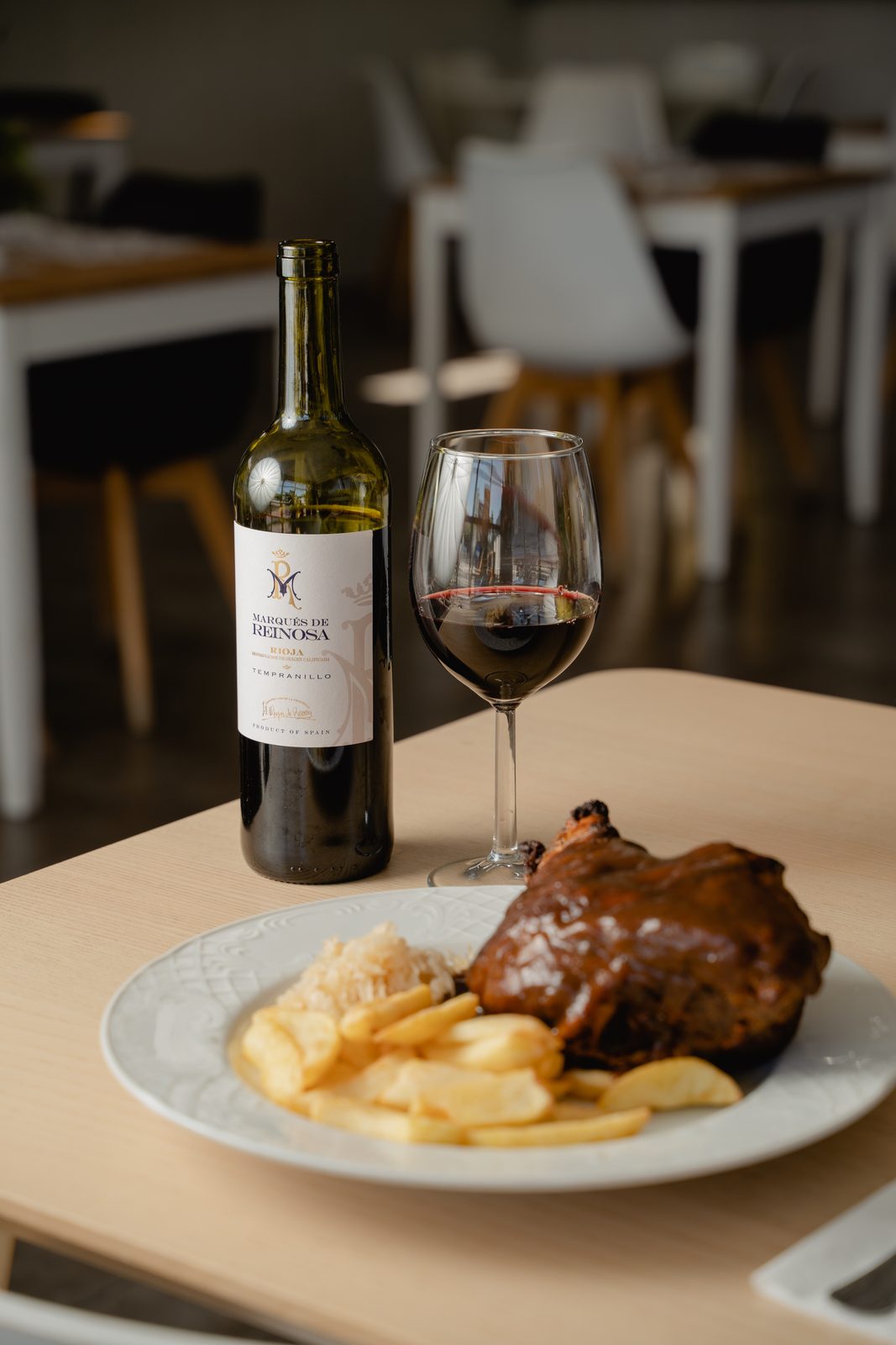 Plato de carne con copa de vino en el restaurante