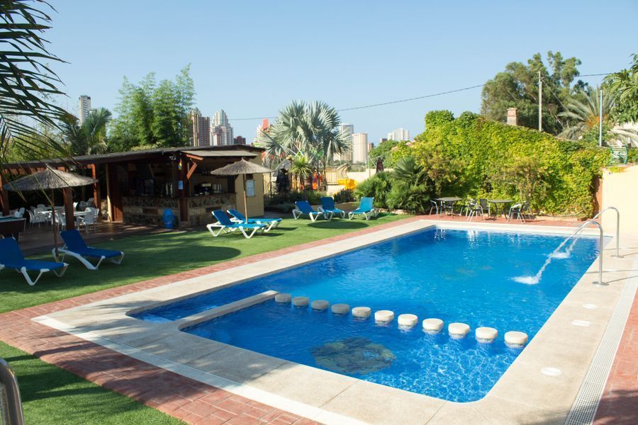 Zona lounge, con bar y piscina de adultos y piscina infantil