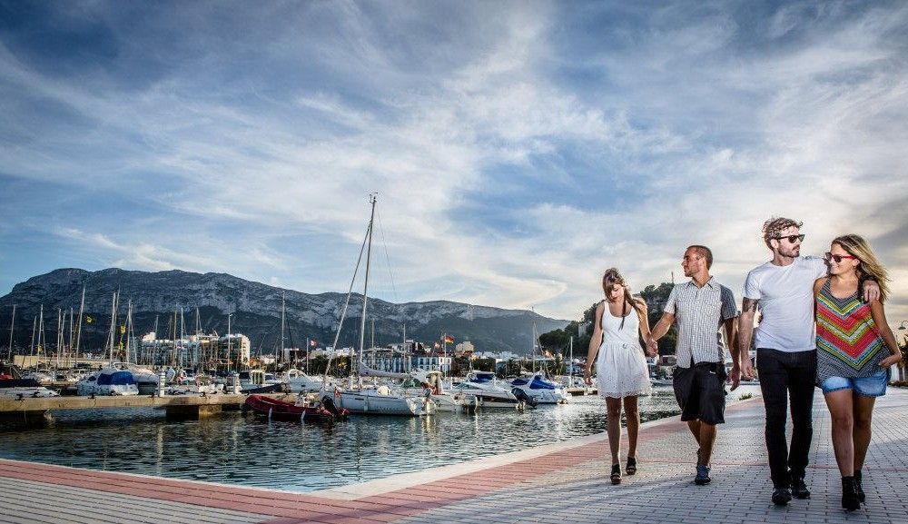 Turister besøker havnen i denia