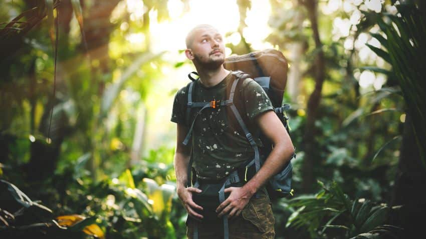 Explorador camina por la selva intentando sobrevivir